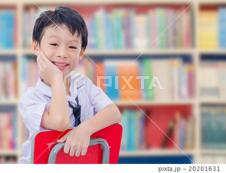 boy student in uniform reading book in library boy student in uniform reading book in library 20201631