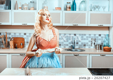 Girl kneads the dough and flirting. 20207427