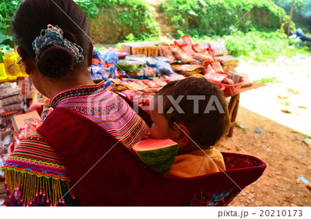 ベトナム北部　バクハの市場　花モン族の親子　すいかを食べる幼児 20210173