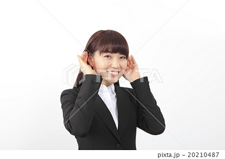 耳に手を当てる女性の写真素材