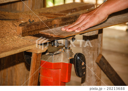 Hand of carpenter working with electric planer Hand of carpenter working with electric planer 20213688