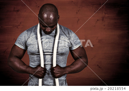 Composite image of fit man with battle rope 20218554