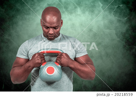 Composite image of fit man exercising with kettlebell  20218559