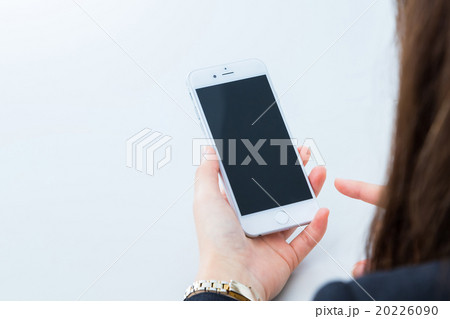 オフィスで携帯を触る女性の手元　コピースペース　スマホ　スマートフォン　携帯電話　白背景 20226090