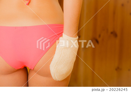 Closeup of woman in sauna with exfoliating glove. Closeup of woman in sauna with exfoliating glove. 20226245