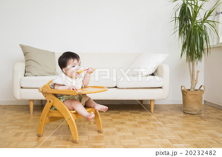 べビーチェアに座って離乳食を食べる赤ちゃん 20232482