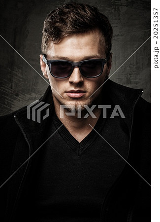 Stylish young man in black coat and sunglasses Stylish young man in black coat and sunglasses 20251357