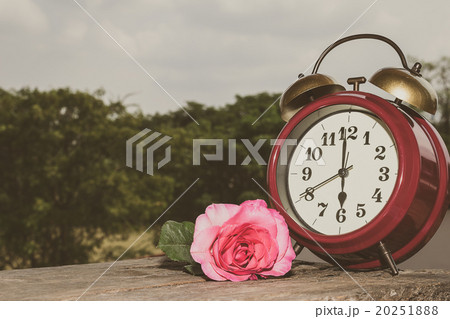 Retro clock with flowers on the wooden floor. Retro clock with flowers on the wooden floor. 20251888