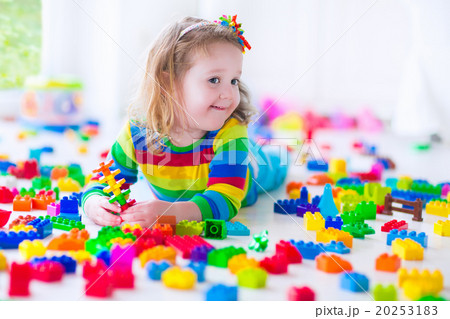 Little girl playing with colorful toy blocks Little girl playing with colorful toy blocks 20253183