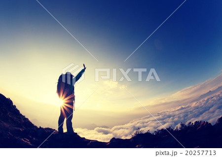 silhouette of backpacker hiking on sunset mountain peak 20257713