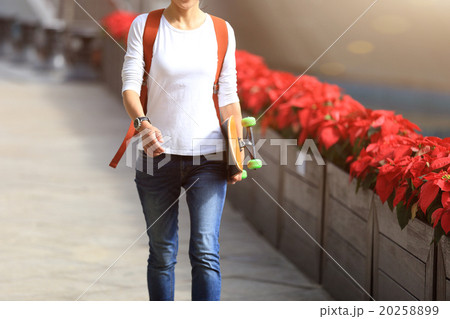 young woman skateboarder walking with skateboard young woman skateboarder walking with skateboard 20258899