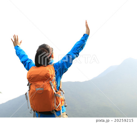 cheering young woman hiker open arms on mountain peak 20259215