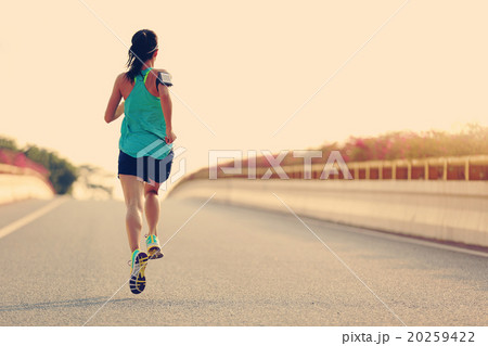 young woman runner running on city bridge road young woman runner running on city bridge road 20259422