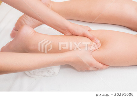 Therapist doing reflexology massage on woman leg  20291006