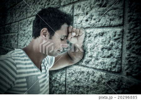 Composite image of upset man leaning on white background Composite image of upset man leaning on white background 20296885