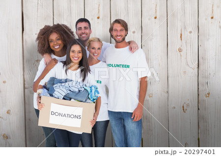 Composite image of smiling group of volunteers holding donation Composite image of smiling group of volunteers holding donation 20297401