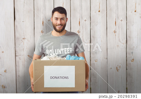 Composite image of portrait of man holding clothes donation box Composite image of portrait of man holding clothes donation box 20298391