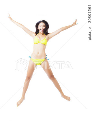 Attractive young woman in bikini jumping Attractive young woman in bikini jumping 20301565