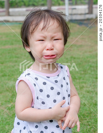 Little Asian girl crying in park Little Asian girl crying in park 20304176