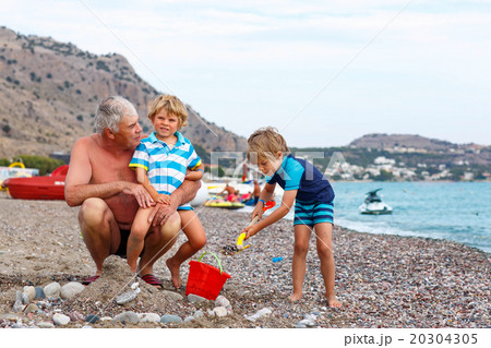 Grandfather and two little kid boys on ocean beach 20304305