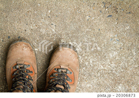 Dirty hiking boots, on concrete floor. 20306873