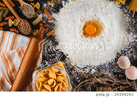 Pasta on dark wooden background with eggs, flour 20309262