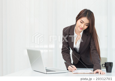 Businesswoman using laptop at office Businesswoman using laptop at office 20312701