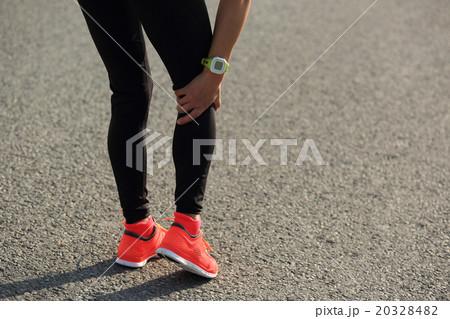 woman runner hold her injured leg on road.. woman runner hold her injured leg on road.. 20328482