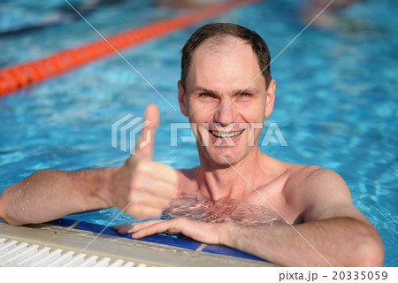 Happy man with thumbs up in a swimming pool Happy man with thumbs up in a swimming pool 20335059