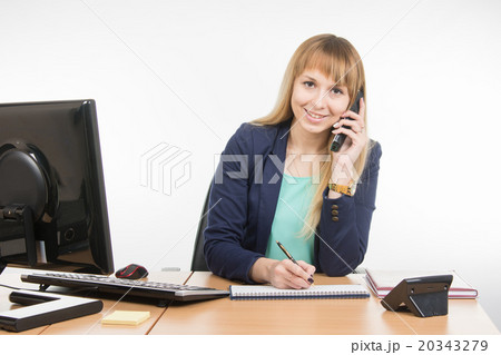 Business woman talking on the phone, writing in a notebook, and looked into the frame 20343279