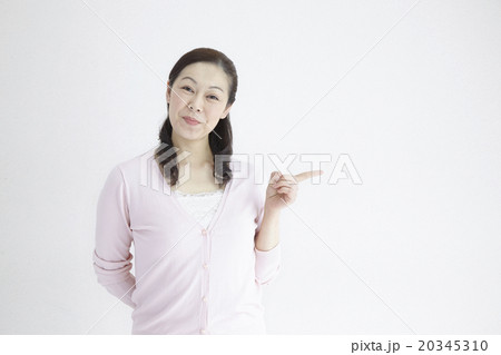 ４０代女性爽やかご案内ポーズ自然光ポートレイト 20345310