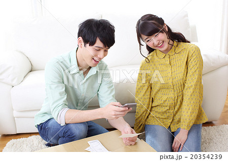 スマホで家計簿を管理する夫婦 スマホで家計簿を管理する夫婦 20354239