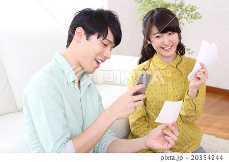 スマホで家計簿を管理する夫婦 スマホで家計簿を管理する夫婦 20354244