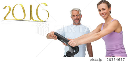 Composite image of portrait of a happy woman on stationary bike 20354657