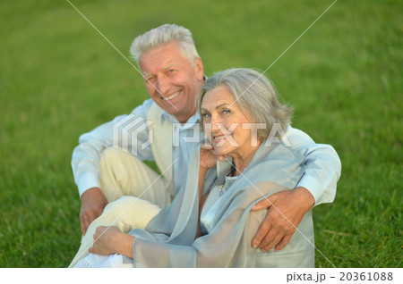 Elderly couple sitting on grass Elderly couple sitting on grass 20361088