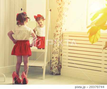 little girl child fashionista looking in the mirror at home 20370744