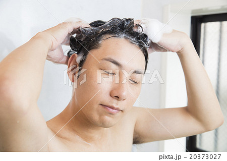 髪の毛を洗う若い男性の写真素材