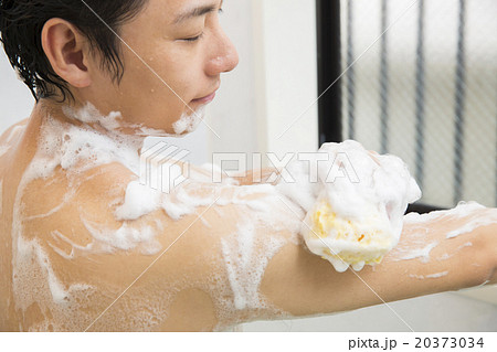 体を洗う若い男性の写真素材