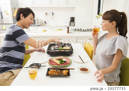 ホットプレートで焼き肉をする若い夫婦 20377735