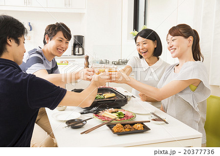 焼肉を食べながら乾杯する若い男女4人 20377736