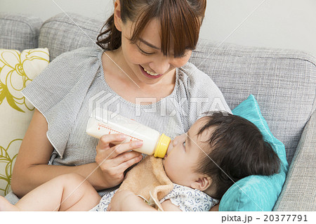 赤ちゃんにミルクを飲ませる若いお母さん 20377791