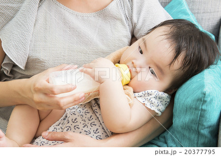 赤ちゃんにミルクを飲ませる若いお母さん 20377795