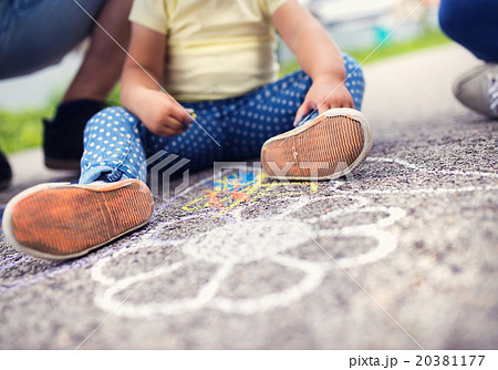 Close up of girl and father drawing with chalks 20381177