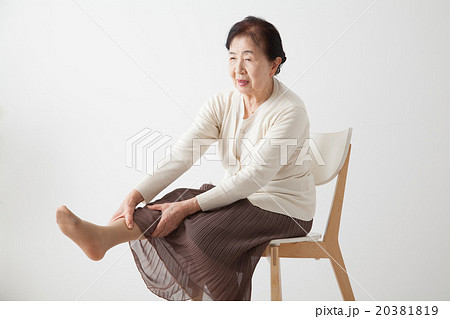 シニア女性 椅子に座って足をのばす リハビリ体操 の写真素材