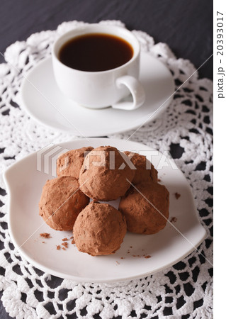 Chocolate truffles on a saucer close-up. Vertical 20393017