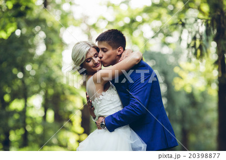 Beautiful wedding couple hugging in the park Beautiful wedding couple hugging in the park 20398877