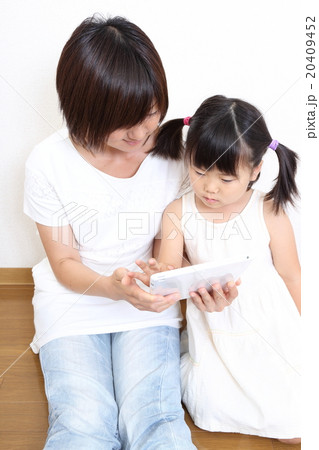 真剣にタブレット端末を見る親子 真剣にタブレット端末を見る親子 20409452