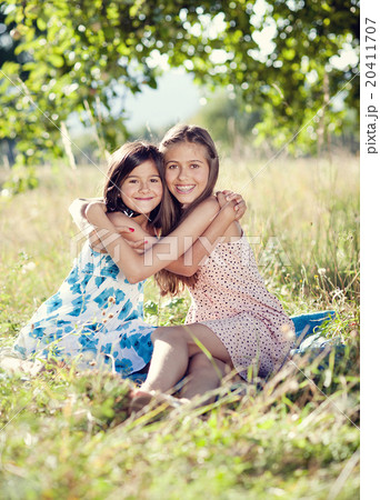 Two sisters in green park 20411707