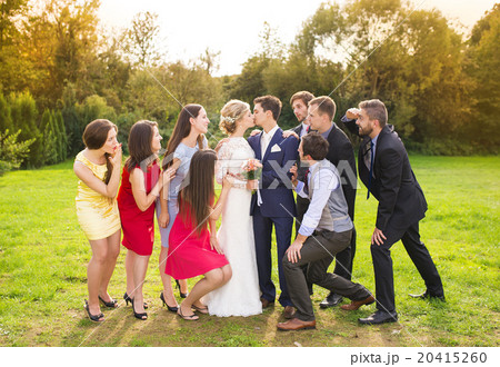 Newlyweds with guest posing in park 20415260