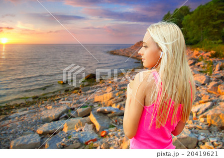 young blond woman standing at sunset young blond woman standing at sunset 20419621